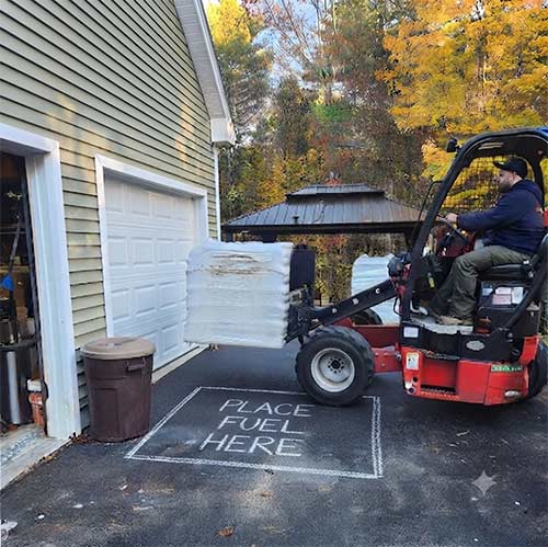 Forklift placing pellets on the driveway